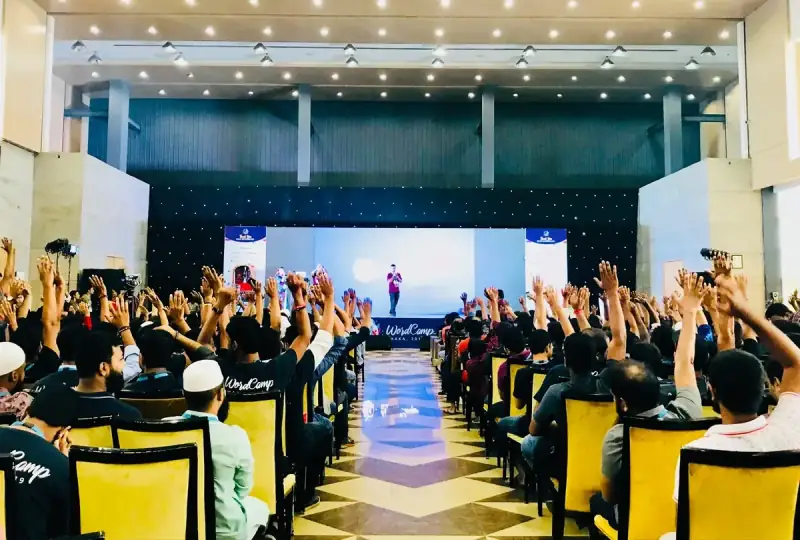 WordCamp Dhaka — a hall with its hands up